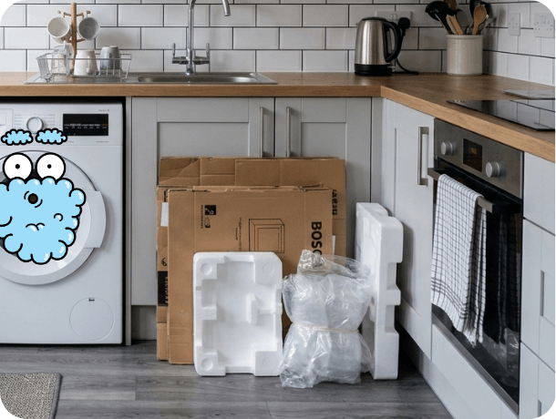Kitchen with unpacked appliance packaging including cardboard, foam inserts, and protective wrapping.