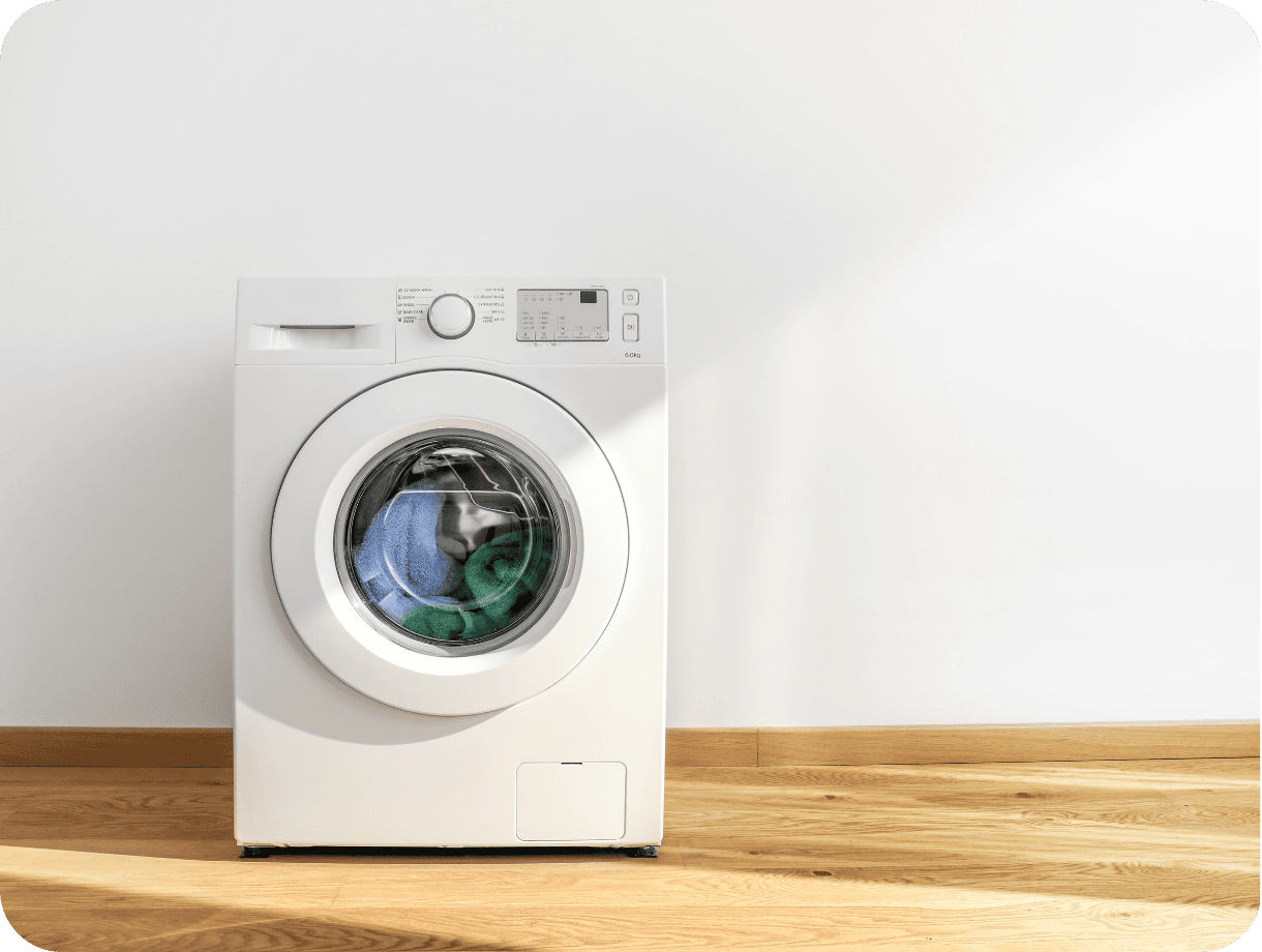 Freestanding washing machine, filled with laundry.